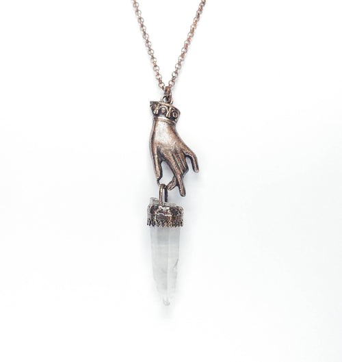 HAND HOLDING CRYSTAL PENDANT